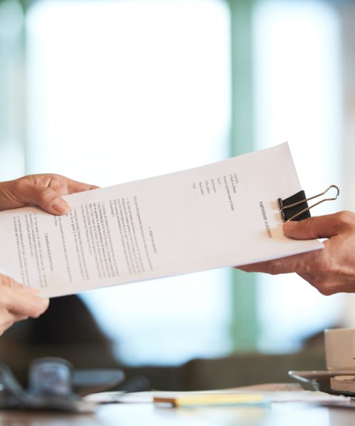 Business person giving partnership agreement to coworker